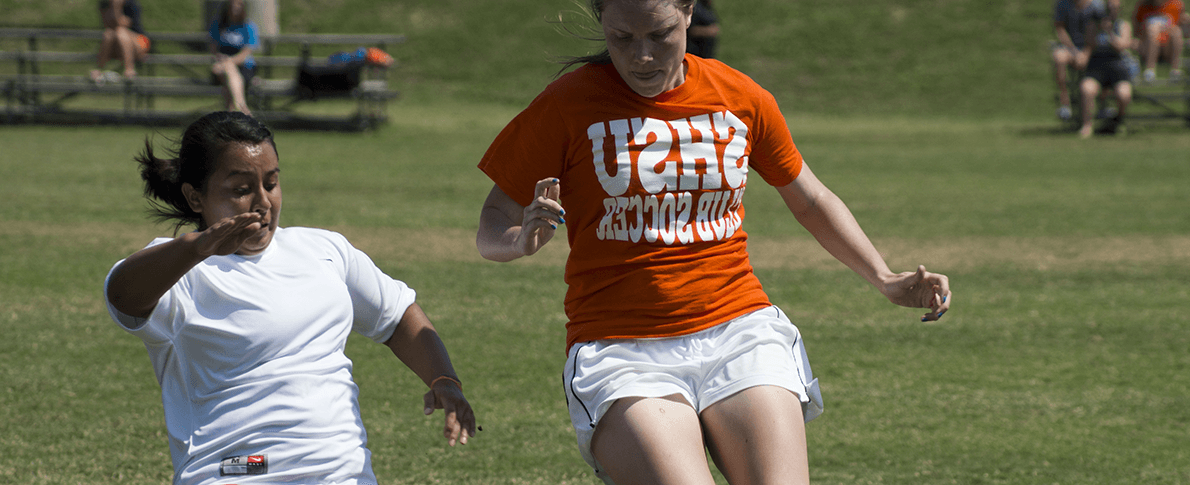 两名女子足球运动员在场上追逐球
